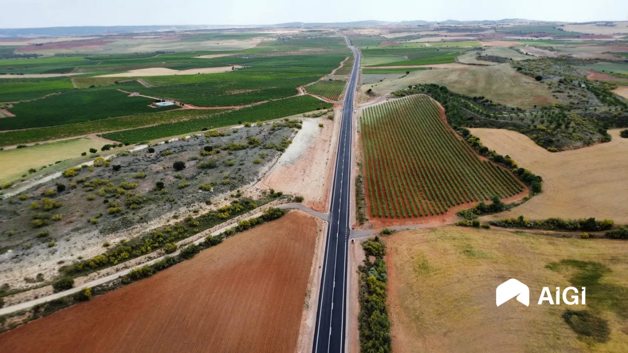 Vista aérea de uma estrada renovada entre vinhas e campos agrícolas em Aragão