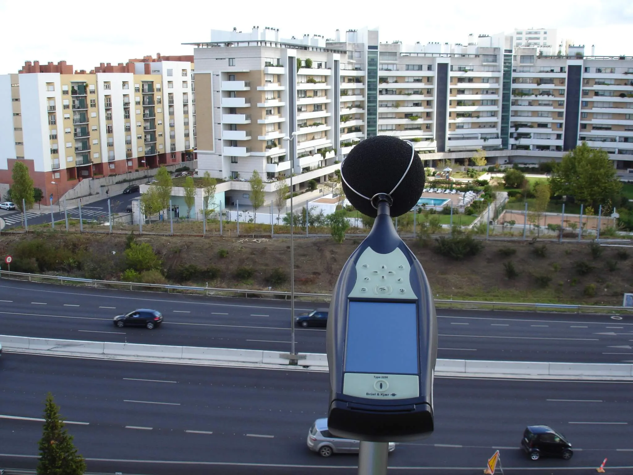 Sonómetro a medir o ruído de uma autoestrada junto a prédios de habitação