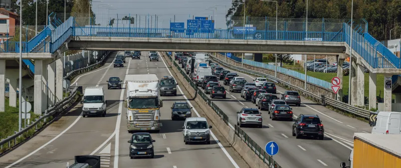 Motorway with heavy traffic under a footbridge