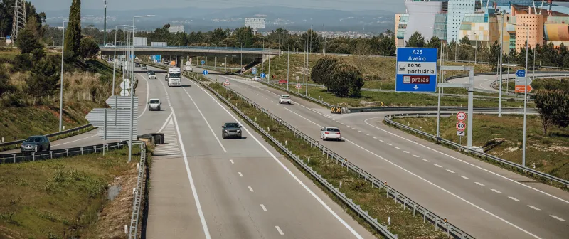 Motorway junction with signs for the A25, next to an urban area