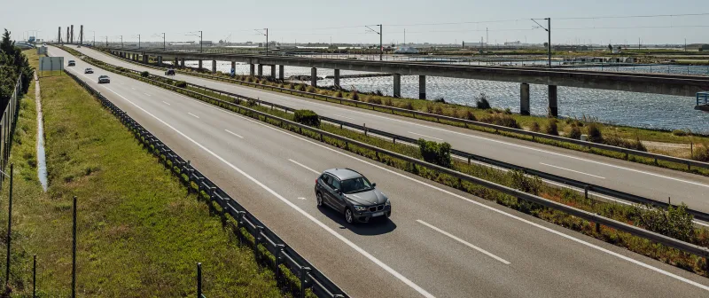 Motorway alongside a canal, with a car in the foreground