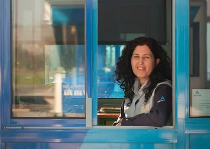 Colaboradora da Ascendi à janela de uma cabine de portagem.