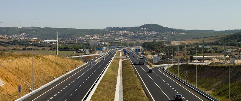 Autoestrada com separador central e uma povoação ao fundo
