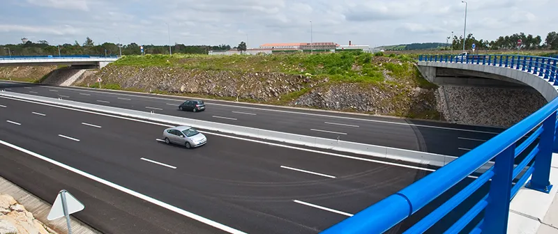 Autoestrada vista de uma ponte com guardas azuis