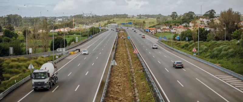 Motorway with a concrete mixer lorry and houses in the distance