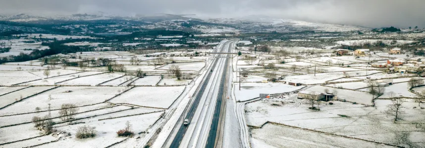 Autoestrada desimpedida a atravessar uma paisagem coberta de neve