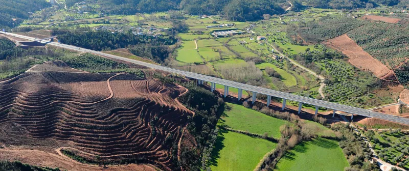 Vista aérea de um viaduto sobre campos agrícolas