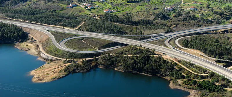 Vista aérea de um nó da autoestrada junto a uma albufeira
